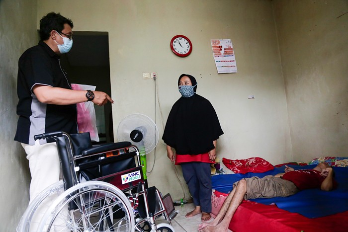Head of CSR MNC Group Tengku Havid (kiri) berbincang dengan Daronah yang merupakan orang tua dari Slamet (21) saat penyerahan bantuan dari MNC Peduli.