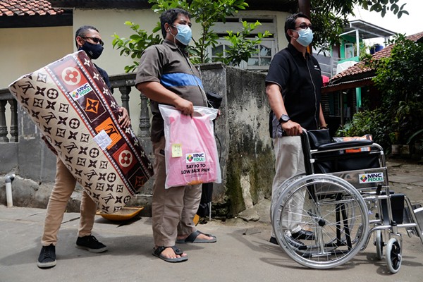 Head of CSR MNC Group Tengku Havid (kiri) berbincang dengan Daronah yang merupakan orang tua dari Slamet (21) saat penyerahan bantuan dari MNC Peduli.