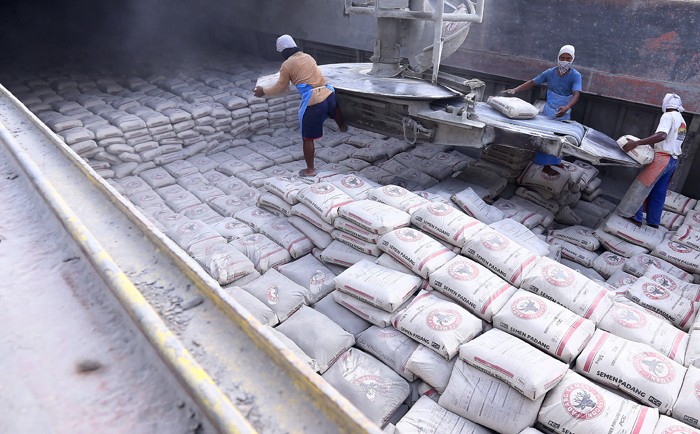 Pekerja memindahkan karung semen ke atas kapal di dermaga Semen Padang, Teluk Bayur, Padang, Sumatera Barat, Rabu (24/11/2021).