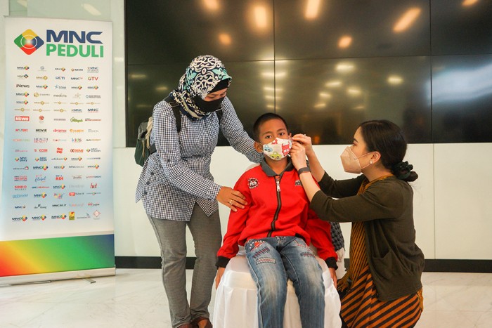 Ketua MNC Peduli Jessica Tanoesoedibjo saat memasangkan alat bantu dengar untuk anak penerima bantuan di Gedung MNC Financial Center, Jakarta Pusat.