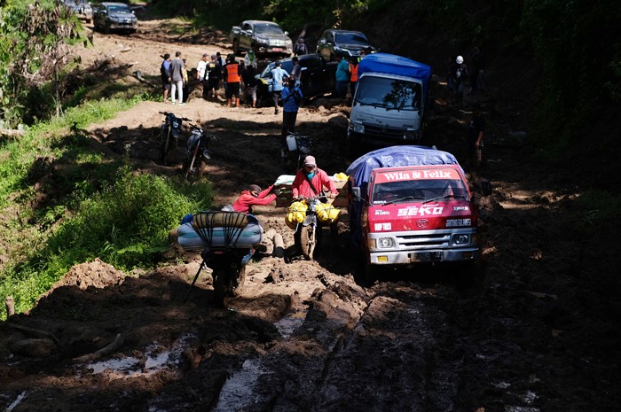 Para tukang ojek seko berusaha mengendalikan sepeda motor yang dipenuhi barang bawaan di Kecamatan Seko, Kabupaten Luwu Utara, Sulawesi Selatan.