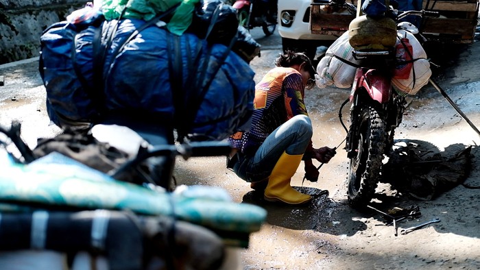 Para tukang ojek seko berusaha mengendalikan sepeda motor yang dipenuhi barang bawaan di Kecamatan Seko, Kabupaten Luwu Utara, Sulawesi Selatan.