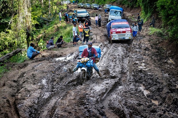 Para tukang ojek seko berusaha mengendalikan sepeda motor yang dipenuhi barang bawaan di Kecamatan Seko, Kabupaten Luwu Utara, Sulawesi Selatan.
