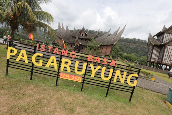 Pengunjung berfoto di halaman Istano Basa Pagaruyung, Batusangkar, Kabupaten Tanah Datar, Sumatera Barat, Sabtu (27/11/2021).