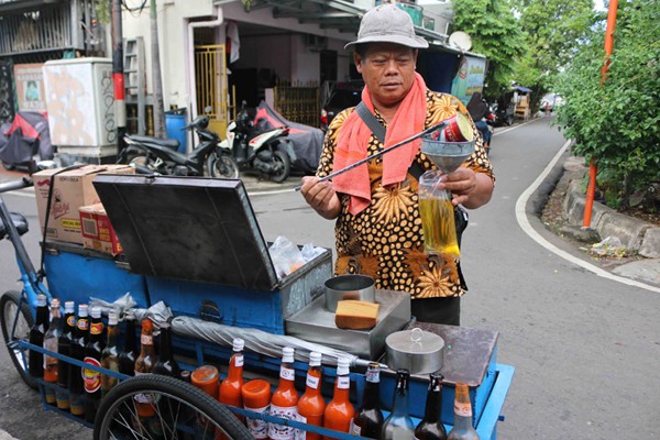 Pedagang minyak goreng curah menuangkan minyak di kawasan jalan serdang Kemayoran Jakarta, Sabtu (27/11/2021).