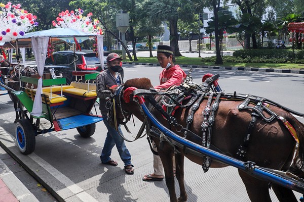 Warga berwisata dengan delman di Kawasan IRTI Monas, Jakarta Pusat, Sabtu (27/11/2021).