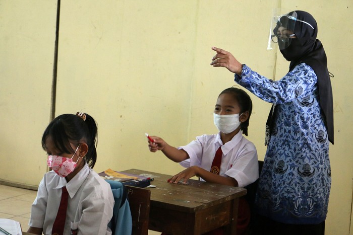 Tenaga pendidik Sekolah Dasar Negeri 01 Pagi Pulau Panggang Provinsi DKI Jakarta menggunakan seragam korpri dalam mengajar pertemuan tatap muka (PTM).