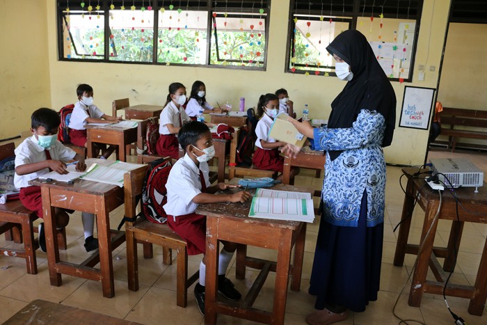 Tenaga pendidik Sekolah Dasar Negeri 01 Pagi Pulau Panggang Provinsi DKI Jakarta menggunakan seragam korpri dalam mengajar pertemuan tatap muka (PTM).