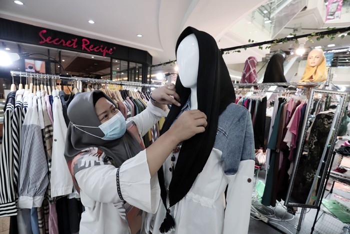 Karyawan merapikan dagangannya di salah satu Pusat Perbelanjaan di kawasan Jakarta Timur, Senin (29/11/2021).