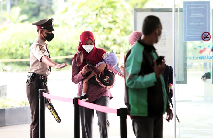 Warga mengunakan aplikasi PeduliLindungi saat akan memasuki pusat perbelanjaan di kawasan Jakarta, Senin (29/11/2021).