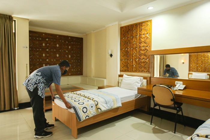 Petugas merapihkan kamar yang nantinya akan digunakan untuk karantina calon jemaah Umrah Indonesia di tengah pandemi Covid-19 di Asrama Haji Pondok Gede.