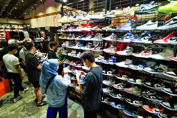 Pengunjung mengamati produk yang ditawarkan pada acara Urban Sneaker Society 2021 di Jakarta Convention Center, Senayan, Jakarta, Minggu (5/12/2021).