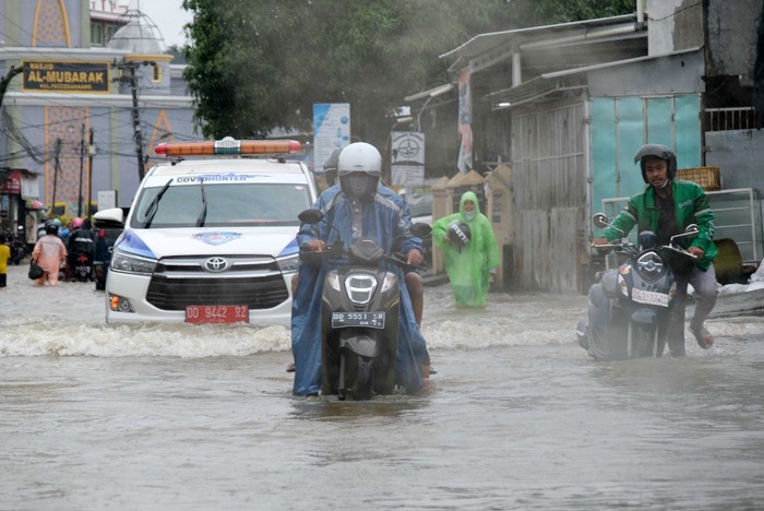 Sejumlah kendaraan menerobos genangan air di Jalan Pacerakkang, Makassar, Senin (6/12/2021).