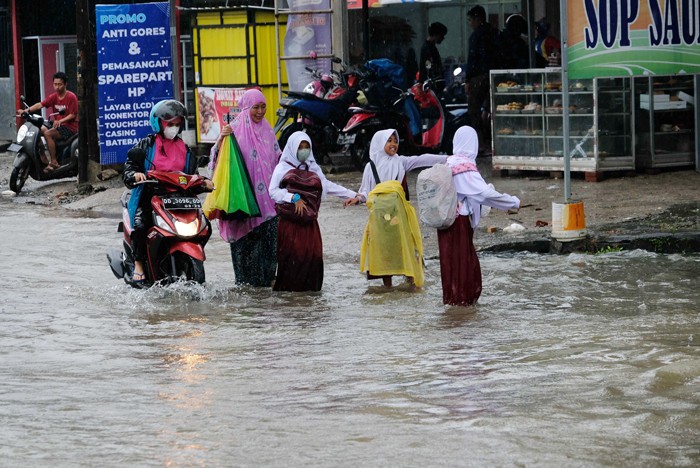 Sejumlah kendaraan menerobos genangan air di Jalan Pacerakkang, Makassar, Senin (6/12/2021).