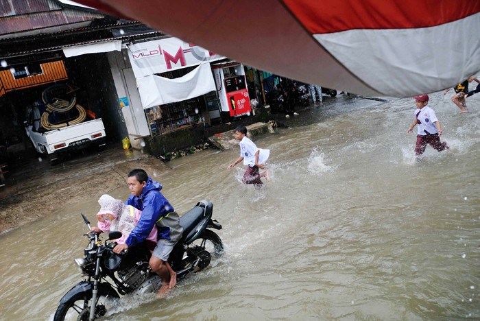 Sejumlah kendaraan menerobos genangan air di Jalan Pacerakkang, Makassar, Senin (6/12/2021).