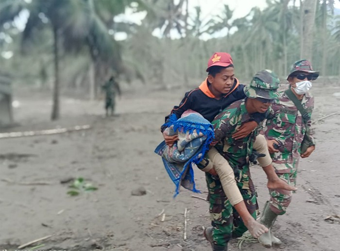 Prajurit TNI AU mengevakuasi seorang anak saat operasi pencarian korban di Desa Sumberwuluh, Lumajang, Jawa Timur, Senin (6/12/2021).