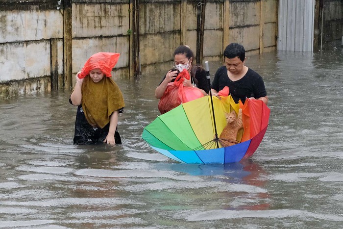 Sejumlah warga melewati banjir untuk mengungsi ketempat yang lebih aman di Makassar, Selasa (7/12/2021).