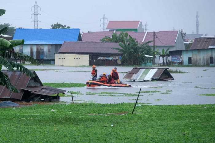 Sejumlah warga melewati banjir untuk mengungsi ketempat yang lebih aman di Makassar, Selasa (7/12/2021).