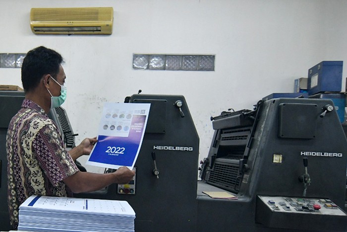 Pekerja saat menyelesaikan pembuatan kalender tahun 2022 di Jakarta Pusat, Senin (6/12/2021).