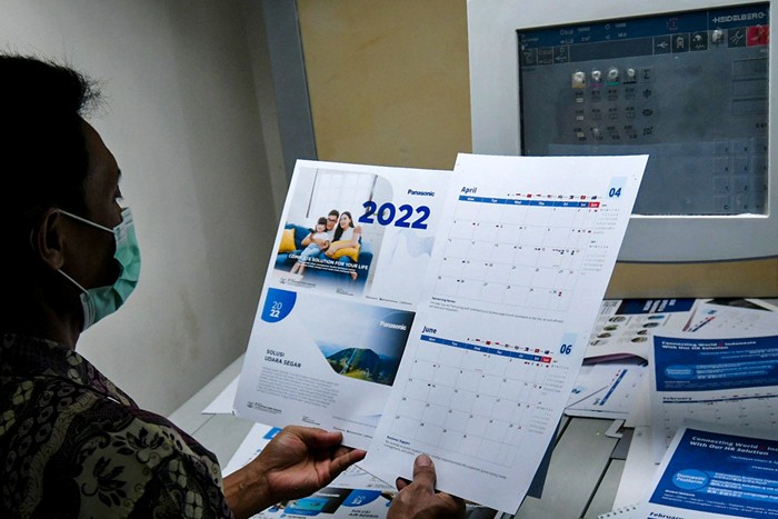 Pekerja saat menyelesaikan pembuatan kalender tahun 2022 di Jakarta Pusat, Senin (6/12/2021).