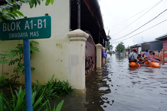Warga menerobos banjir di Kompleks Perumahan Swadaya Mas, Keluarahan Batua, Kecamatan Manggala, Makassar, Sulawesi Selatan, Selasa (7/12/2021).