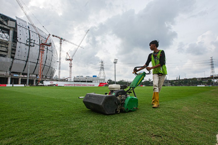Petugas saat melakukan perawatan lapangan latihan Jakarta International Stadium (JIS) di Tanjung Priok, Jakarta Utara, Selasa (7/12/2021).
