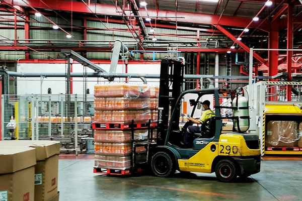 Pekerja saat mengecek produk pada proses pembuatan minuman menyegarkan, berkualitas tinggi dan aman di Pabrik Coca-Cola.