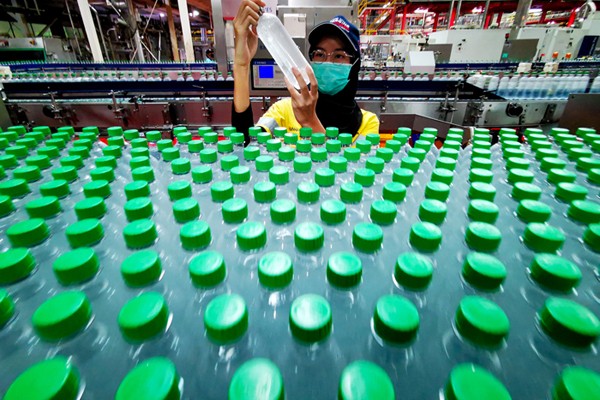 Pekerja saat mengecek produk pada proses pembuatan minuman menyegarkan, berkualitas tinggi dan aman di Pabrik Coca-Cola.