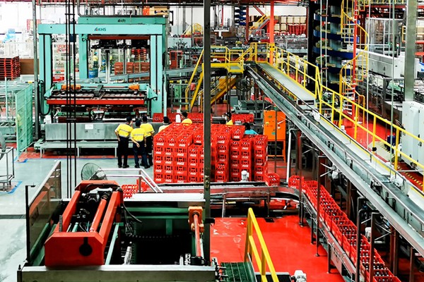Pekerja saat mengecek produk pada proses pembuatan minuman menyegarkan, berkualitas tinggi dan aman di Pabrik Coca-Cola.
