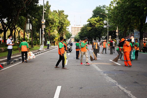 Sejumlah petugas gabungan PPSU dan Dinas Lingkungan Hidup gerak cepat membersihkan sampah sisa unjuk rasa buruh di Jalan Merdeka Selatan.