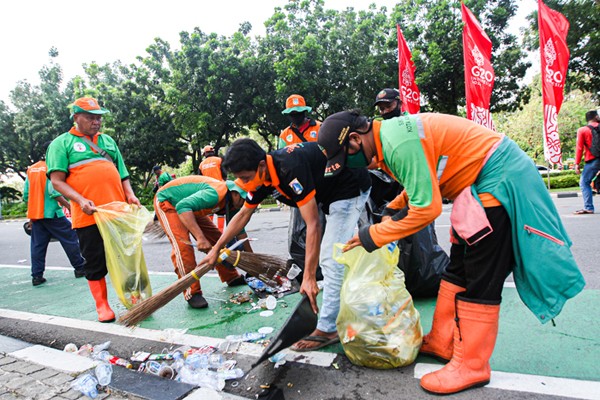 Sejumlah petugas gabungan PPSU dan Dinas Lingkungan Hidup gerak cepat membersihkan sampah sisa unjuk rasa buruh di Jalan Merdeka Selatan.