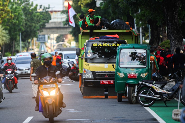 Sejumlah petugas gabungan PPSU dan Dinas Lingkungan Hidup gerak cepat membersihkan sampah sisa unjuk rasa buruh di Jalan Merdeka Selatan.