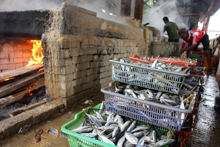 Pekerja merebus ikan yang sudah direndam garam untuk dijadikan ikan asin di pemukiman Nelayan, Muara Angke, Jakarta, Sabtu (11/12/2021).
