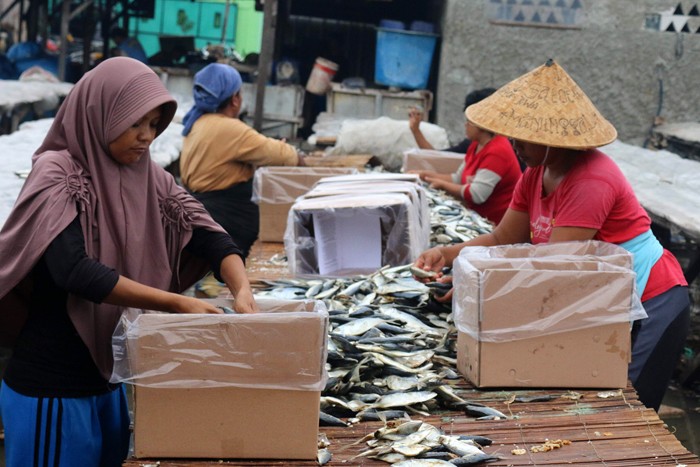 Pekerja merebus ikan yang sudah direndam garam untuk dijadikan ikan asin di pemukiman Nelayan, Muara Angke, Jakarta, Sabtu (11/12/2021).