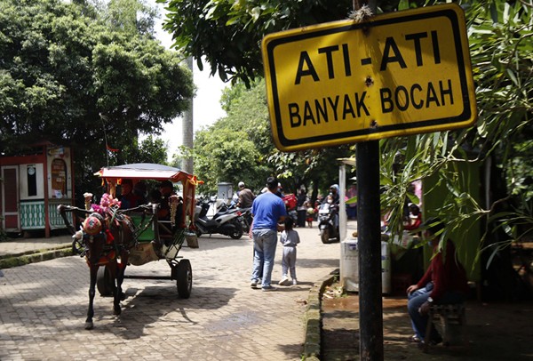 Pengunjung berwisata di kawasan Setu Babakan, Jakarta, Sabtu (11/12/2021).