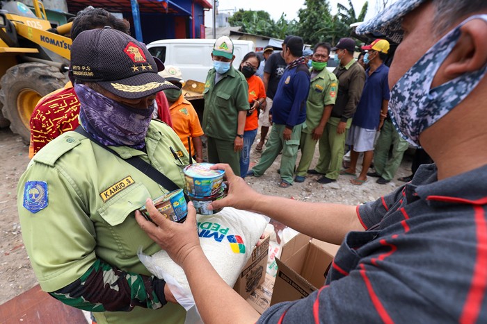 MNC Peduli salurkan beras dan sereal kepada Ketua RW 04 Sofwan Lutfie (kedua kiri) di Kelurahan Kedoya Utara, Jakarta Barat, Selasa, (14/12/2021).