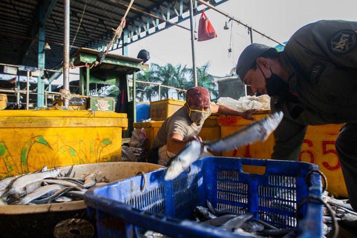 Pedagang saat mensortir ikan untuk dijual di Pasar Ikan Muara Angke, Jakarta Utara, Senin (13/12/2021).