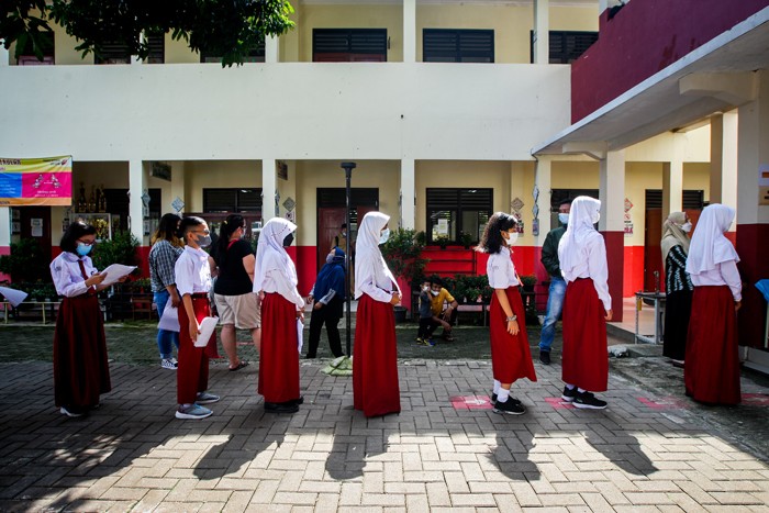 Potret Siswa Sekolah Dasar (SD) usia 6-11 tahun saat menerima dosis vaksin Covid-19 jenis Sinovac di SDN Depok 1, Jawa Barat, Selasa (14/12/2021).