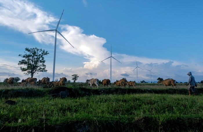 Warga beraktivitas di sekitar baling baling raksasa Pembangkit Listrik Tenaga Bayu (PLTB) Tolo, Kabupaten Jeneponto.