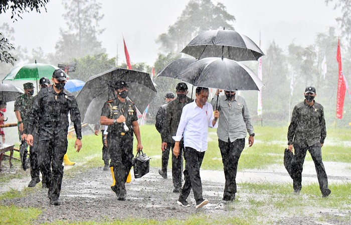 Presiden Joko Widodo basah kuyup meski berpayung usai penanaman cabai bersama masyarakat di Food Estate, Desa Lamuk, Wonosobo, Jawa Tengah, Selasa (14/12/2021).