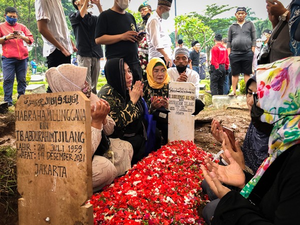 Petugas membantu keluarga memakamkan jenazah Haji Lulung di TPU Karet Bivak, Tanah Abang, Jakarta Pusat, Selasa (14/12/2021).