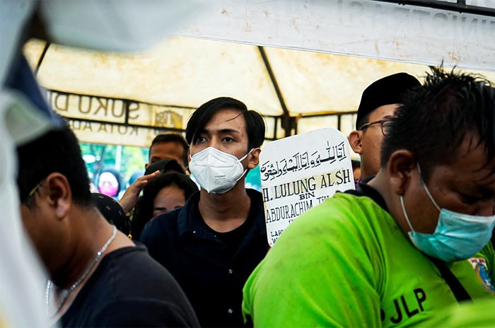Petugas membantu keluarga memakamkan jenazah Haji Lulung di TPU Karet Bivak, Tanah Abang, Jakarta Pusat, Selasa (14/12/2021).