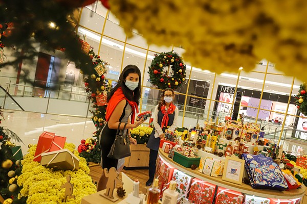 Pengunjung berfoto dengan latar belakang instalasi Golden Giant Christmas Tree di Atrium Pusat Perbelanjaan Senayan City, Jakarta Pusat, Selasa (14/12/2021).