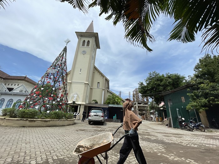 Pengurus panitia Natal membersihkan area Gereja Katedral, Makassar, Senin (20/12/2021).