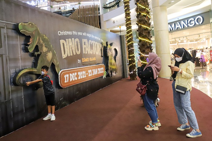 Pengunjung menyaksikan replika hewan prasejarah dalam wahana Dino Factory by Dino Island di Mal Kota Kasablanka, Jakarta Selatan, Senin (20/12/2021).