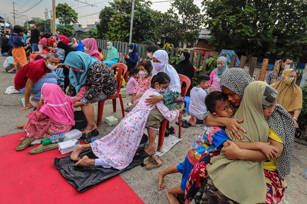 Seorang anak mencuci kaki ibu dalam kegiatan bertajuk 