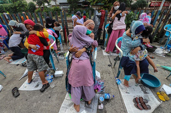 Seorang anak mencuci kaki ibu dalam kegiatan bertajuk 