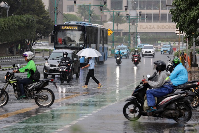 Pengendara melintas di jalan saat hujan di kawasan Imam Bonjol, Jakarta, Kamis (23/12/2021).