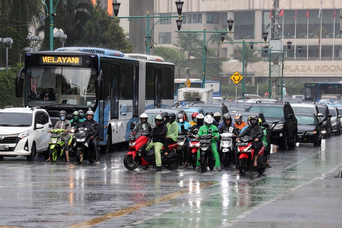 Pengendara melintas di jalan saat hujan di kawasan Imam Bonjol, Jakarta, Kamis (23/12/2021).