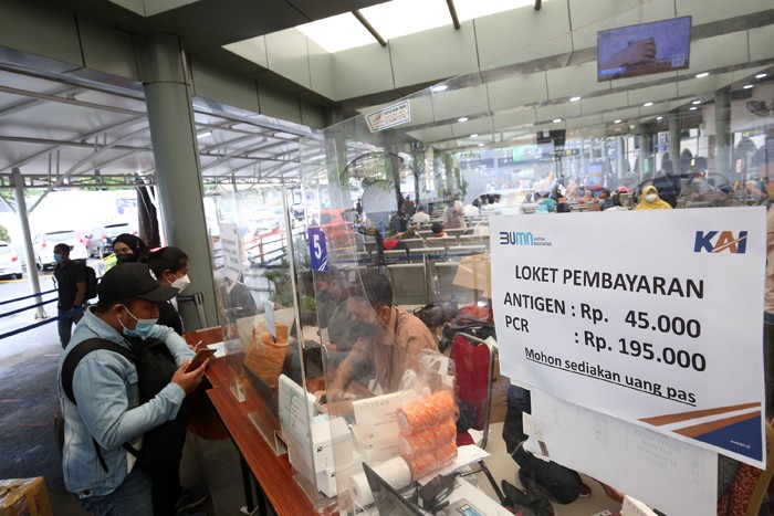 Petugas kesehatan melakukan tes swab PCR pada seorang anak di Stasiun Pasar Senen, Jakarta, Kamis (23/12/2021).